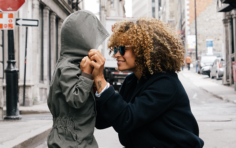 mom putting a hood on her kid
